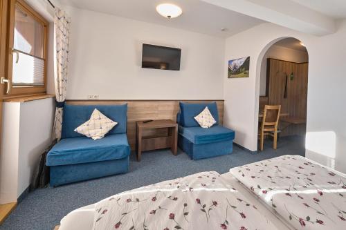 a hotel room with two beds and a table and chairs at Gästehaus Sonnenbichl in Berchtesgaden