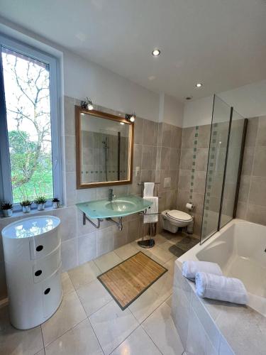 une salle de bain avec un lavabo, une baignoire et des toilettes dans l'établissement Ailleurs sous les étoiles, à Manneville-la-Raoult