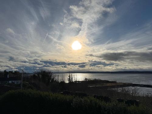 a sunset over the water with the sun in the sky at The Inn At Charlestown in Dunfermline