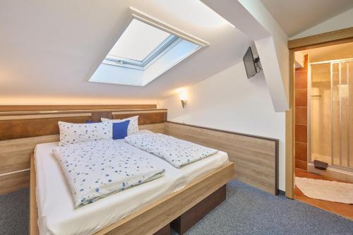 a bedroom with a large bed with a skylight at Gästehaus Sonnenbichl in Berchtesgaden