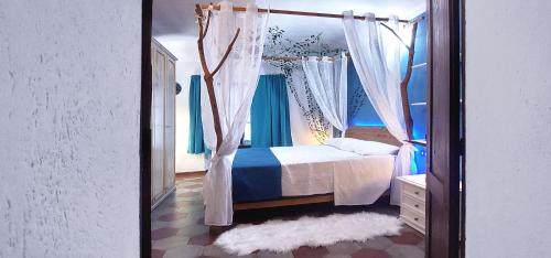 1 dormitorio con cama con dosel y cortinas azules en Fairy Castle, en Castelnuovo Don Bosco