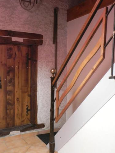 a staircase in a house with a wooden door at Chambre d'hôtes Domaine de la Guinchère in LʼHôpital-le-Mercier