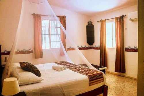 a bedroom with a bed with a mosquito net at Private Beachhouse Hacienda Antigua in El Cuyo