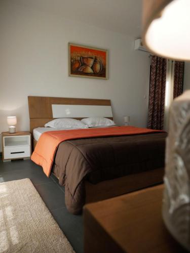 a bedroom with a bed with an orange blanket at Résidence Bambou in Dakar