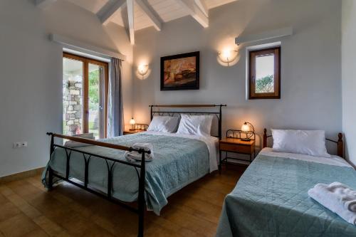 a bedroom with two beds and two windows at OpenSea Villa in Thermisía