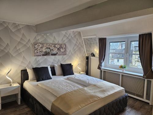 a bedroom with a large bed and a window at Hotel Schloßschenke in Idar-Oberstein