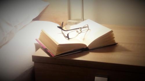 an open book with a pair of glasses on a table at Gästehaus Karl August in Fohnsdorf