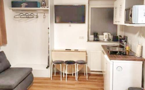 a small kitchen with two stools in a small apartment at Stuttgart City Apartment A in Stuttgart