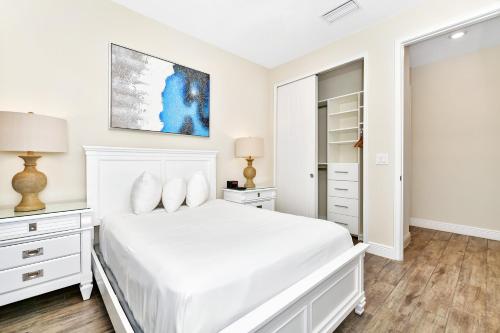 a white bedroom with a bed and a closet at Margaritaville Cottages Orlando with H2O Waterpark by Rentyl in Kissimmee