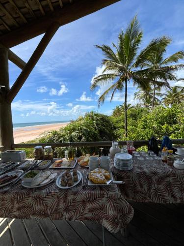 a table with plates of food and a palm tree at Casa Del Mar in Marau
