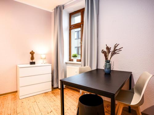 a dining room with a black table and chairs at OH KEY Apartments - unlock your stay - Zentral in Fulda-City in Fulda