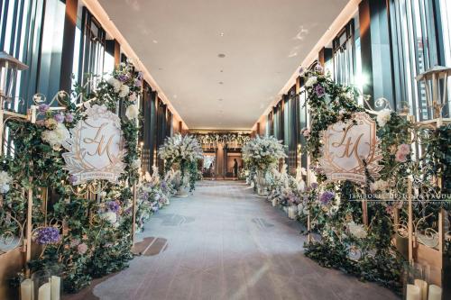 a corridor with flowers and chairs in a building at The St. Regis Hong Kong in Hong Kong