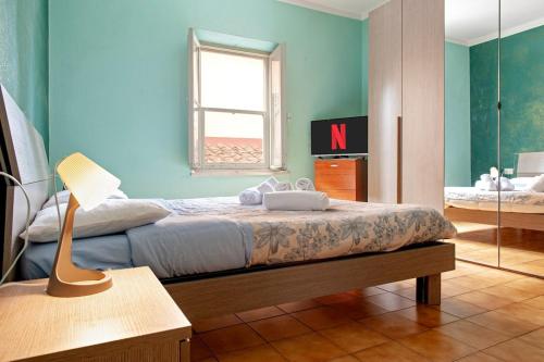 a bedroom with a bed with a lamp and a window at Bilocale Strategico in Centro in Pontedera
