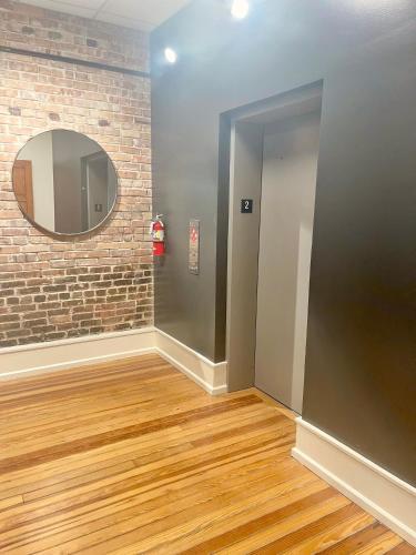 a hallway with a mirror on a brick wall at Luxe 220, Unit 5 - Adjacent City View Suites in Wilmington