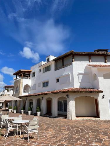 a building with chairs and tables in front of it at 2BR Beachfront Cadaques Caribe in Bayahibe