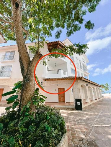 a building with a red circle on it next to a tree at 2BR Beachfront Cadaques Caribe in Bayahibe