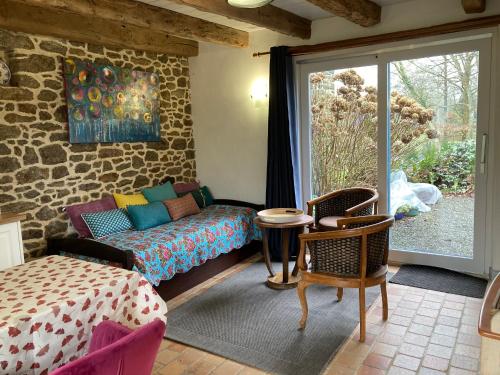 un salon avec un canapé et une table dans l'établissement Au Pont Ricoul, à Saint-Pierre-de-Plesguen