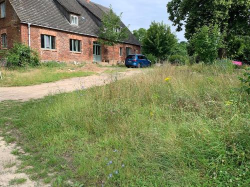 a blue van parked in front of a brick building at Nachhaltige Wohnung im Seenland in Cantnitz