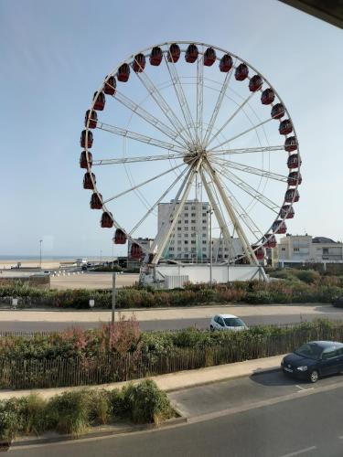 une grande roue ferris devant un bâtiment dans l'établissement Appartement face mer, à Berck-sur-Mer