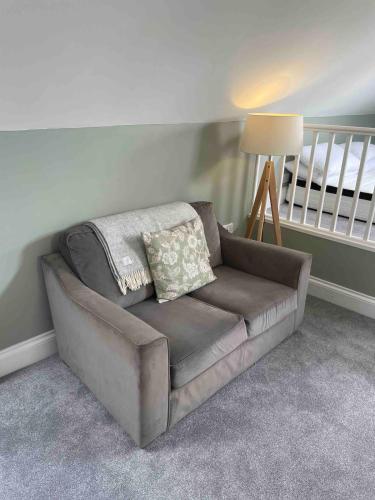 a couch in a living room with a lamp at Sea Glimpses Studio Port Isaac in Port Isaac
