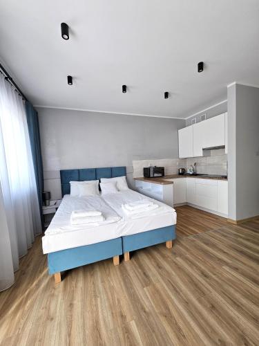 a large bedroom with a bed and a kitchen at Masurian Apartments in Mrągowo