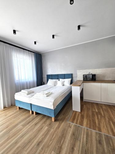 a bedroom with a large bed and a desk at Masurian Apartments in Mrągowo