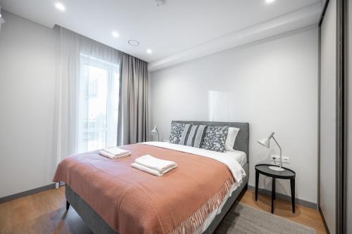 Un dormitorio con una cama grande con dos toallas encima. en Brand New Downtown Apartments by Reside Baltic, en Vilna