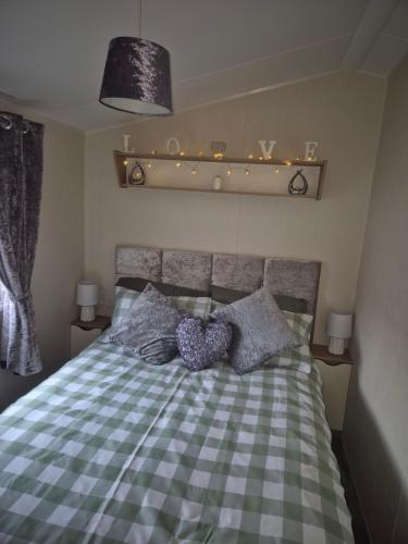 a bedroom with a checkered bed with two pillows at 3 bedroom Caravan Craigtara in Ayr