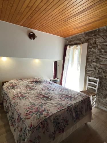 une chambre avec un lit et un mur en pierre dans l'établissement Charming stay in an Authentic Corsican Village, à Zalana