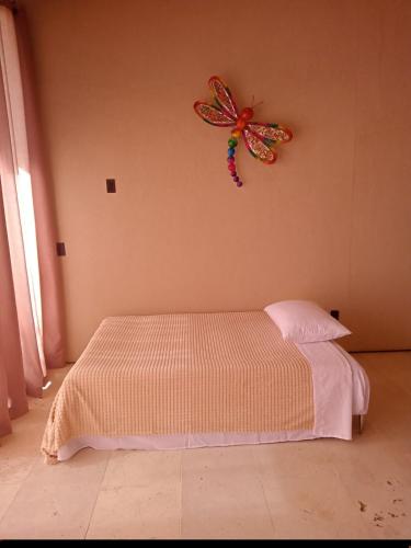 a bedroom with a butterfly decoration on the wall at Casa Yazmín- Viñedos Puerta del Lobo in Amascala