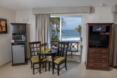 ein Wohnzimmer mit einem Esstisch und Meerblick in der Unterkunft Best Western Hotel Posada Freeman Zona Dorada in Mazatlán