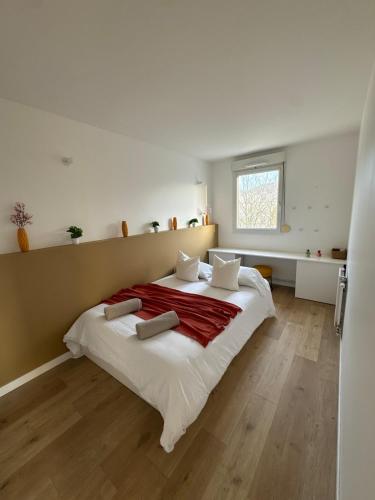 - une chambre avec un grand lit blanc et des draps rouges dans l'établissement Logement familial près de Disney, à Bussy-Saint-Georges