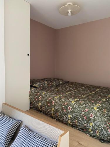 une chambre avec un lit avec un couvre-lit fleuri dans l'établissement Studio 2-3 pers, à La Gaubretière