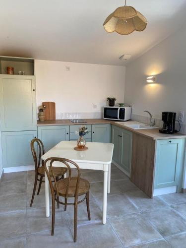 une cuisine avec une table et des chaises et un micro-ondes dans l'établissement Studio 2-3 pers, à La Gaubretière