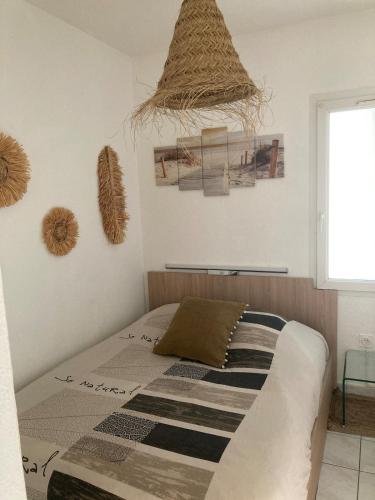 - une chambre avec un lit et des photos sur le mur dans l'établissement Appartement dans villa à 600m de la plage, à Fréjus