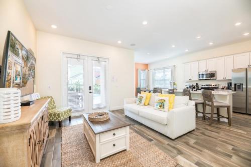 a living room with a white couch and a table at Margaritaville Cottages Orlando with H2O Waterpark by Rentyl in Kissimmee