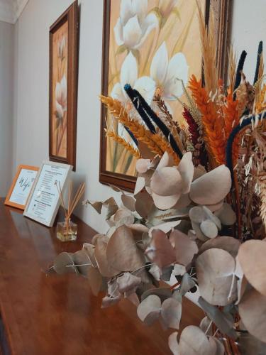 a table with a vase filled with shells and flowers at Casa Carmen in Vélez Rubio