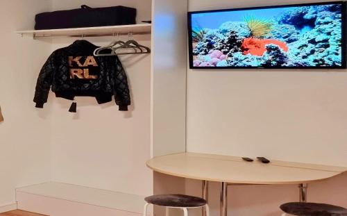 a television hanging on a wall with a coat and a table at Stuttgart City Apartment A in Stuttgart