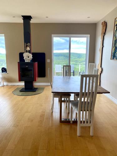 a dining room with a table and a wood stove at Eagles Perch in Margaree