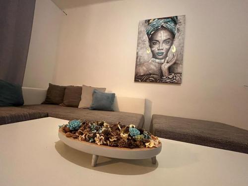 a living room with a couch and a bowl on a table at Apartman Cañas Modrá Víla in Rimavská Sobota