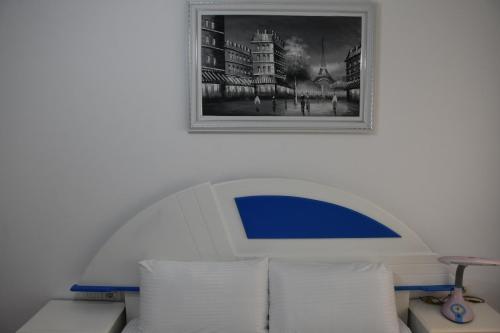 a picture on a wall above a couch with pillows at Leo Apartment in Përmet