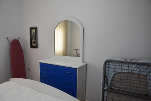 a bedroom with a blue dresser and a mirror at Leo Apartment in Përmet