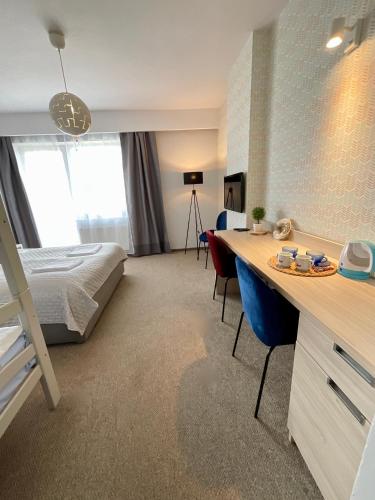 a hotel room with a bed and a desk with chairs at WiLLA APART in Władysławowo