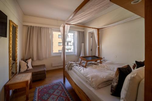 a bedroom with a canopy bed and a window at Oslo Guldsmeden in Oslo