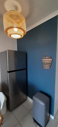 Cette chambre lumineuse est dotée d'un mur bleu et d'un réfrigérateur. dans l'établissement Résidence le Village de Cap Esterel - maeva Home - Appartement 2 Pièces 5 Personnes - Vue mer - Sélection MAE-5414, à Saint-Raphaël