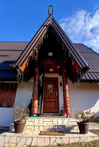 a small white house with a red door at Forest house ALEKSANDAR in Srbac