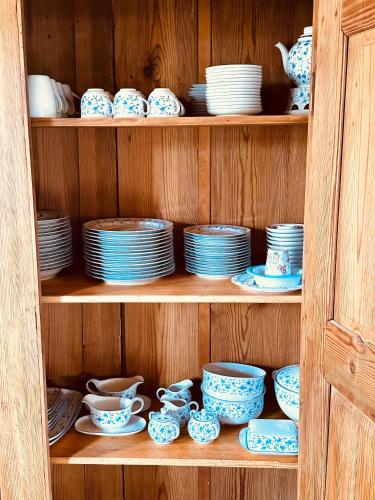 a wooden shelf with blue and white plates and cups at Ickelhaus 2 in Bad Windsheim