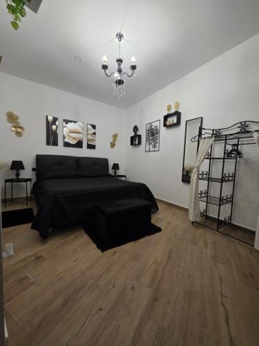 a bedroom with a black bed and a chandelier at Elite Apartment SPA in Catania