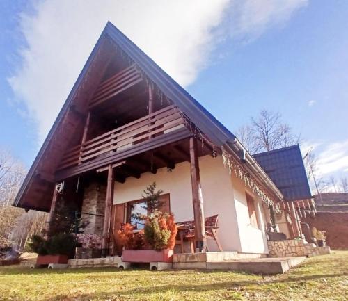 a small white house with a bench in front of it at Forest house ALEKSANDAR in Srbac