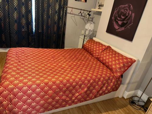 a red couch sitting in a room with a window at A Place to stay in Kettering in Kettering